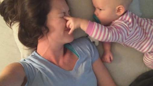 Відкриває очі й залазить на шию: мама виклала кумедне відео з донькою, яка заважає їй спати
